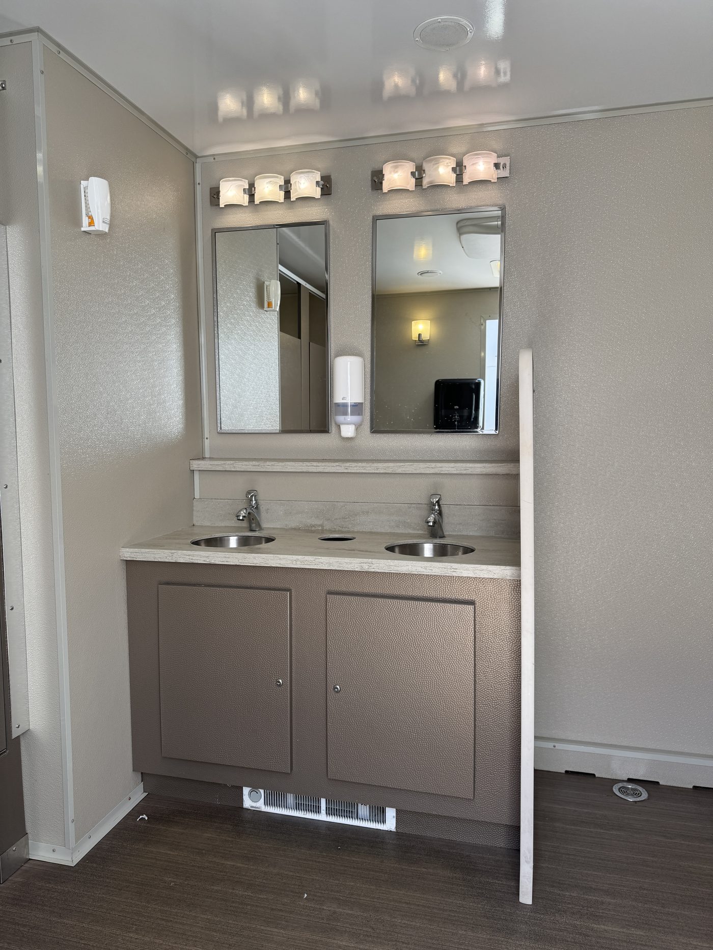 Double-sink vanity interior of a restroom trailer suitable for office staff during a renovation