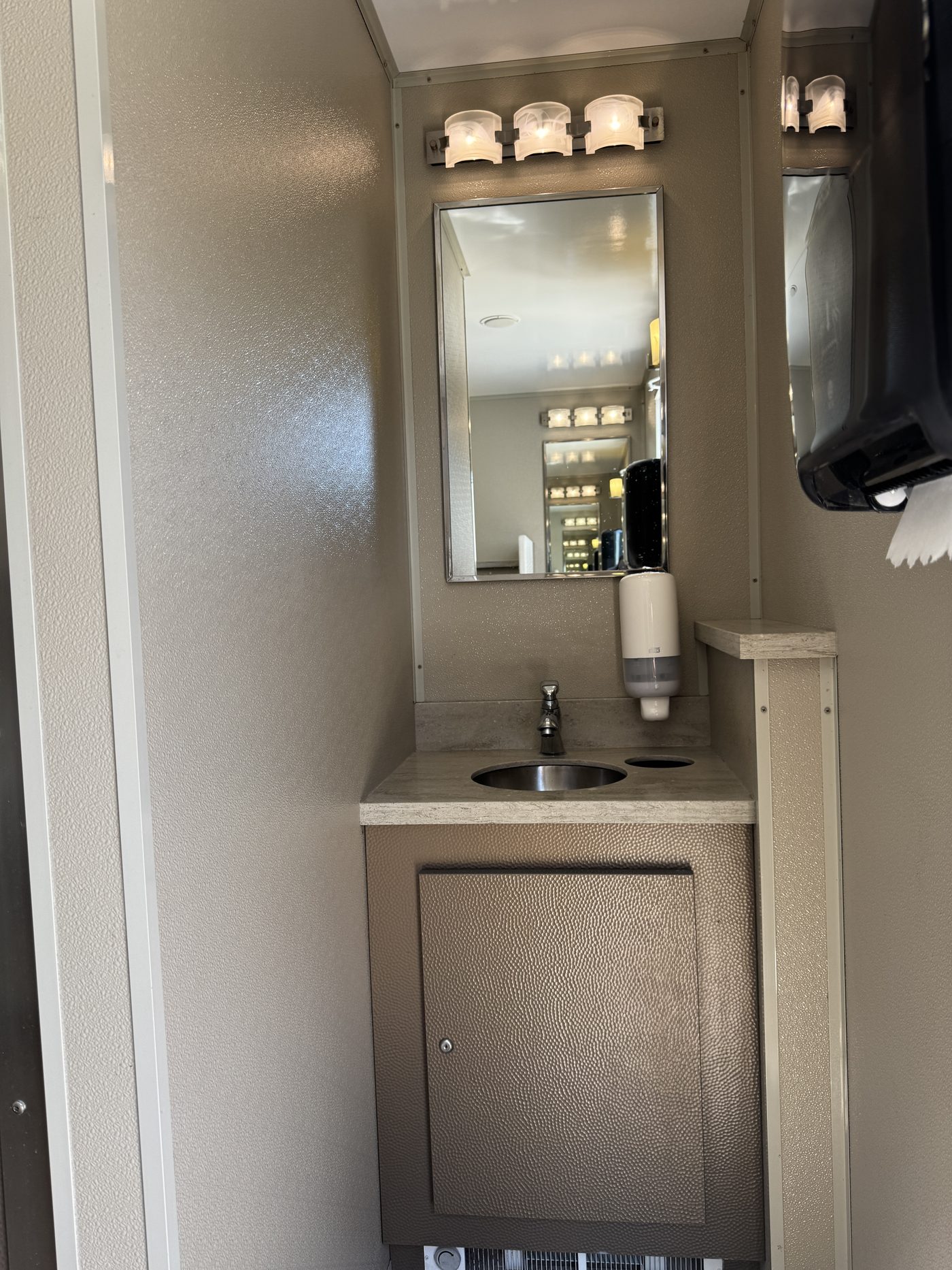 Clean single-vanity restroom trailer interior suitable for a school or temporary campus
