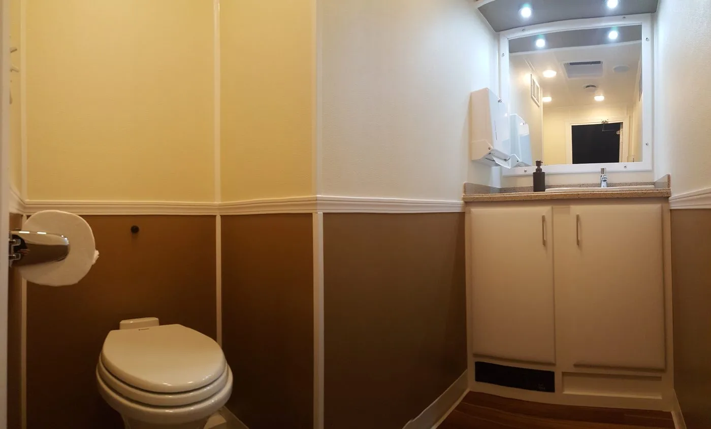 Interior of the 3-station restroom trailer showing vanity, mirror, recessed lighting and hardwood floor