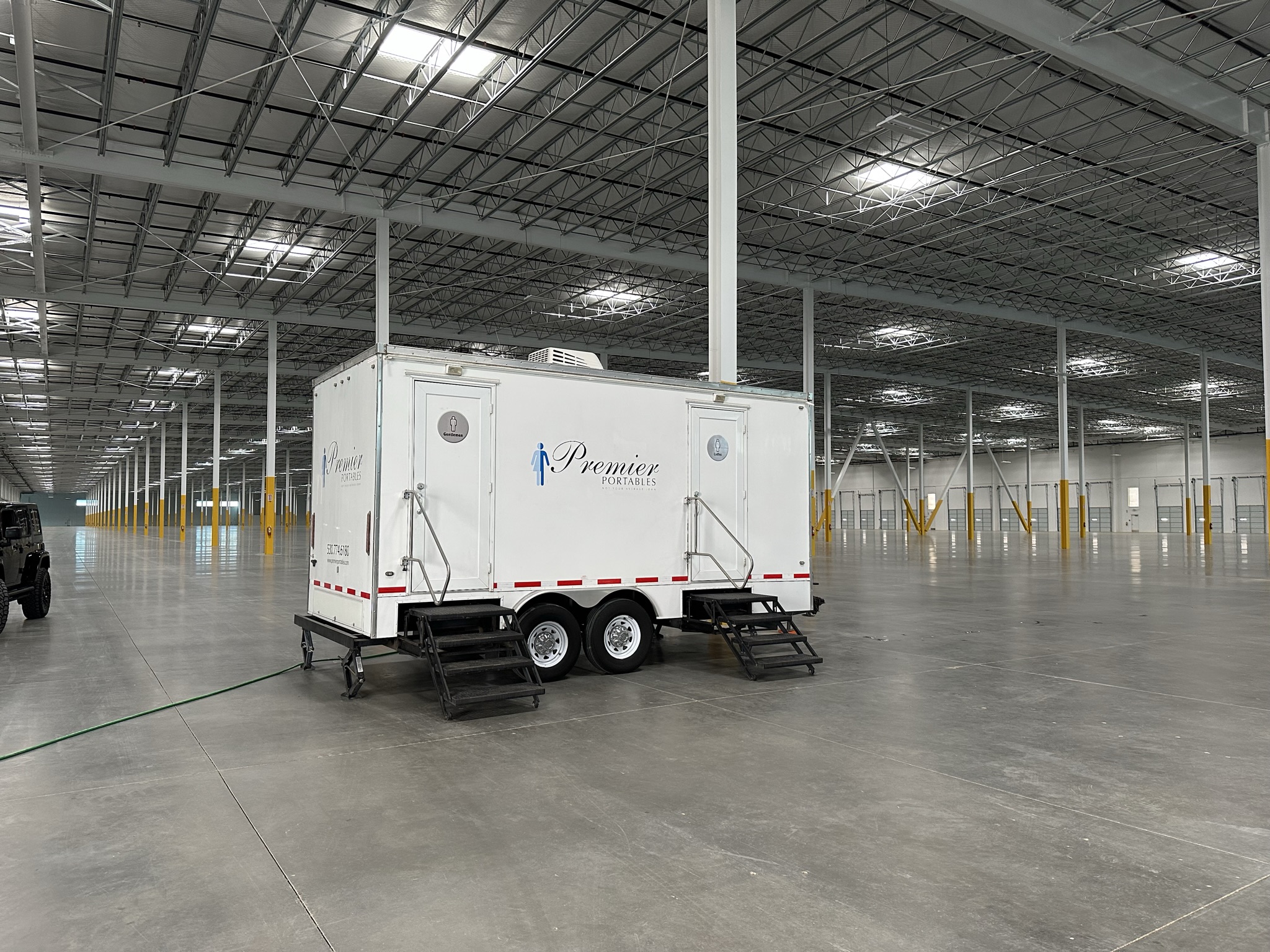 Restroom trailer set up inside a warehouse for a long-term facility rental